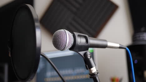 a vocal microphone and pop filter for singing or recording a podcast in a bedroom music studio slide left