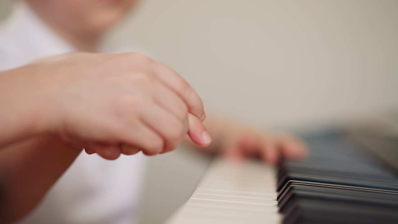 una niña pequeña toca el piano con el dedo índice de un niño pequeño