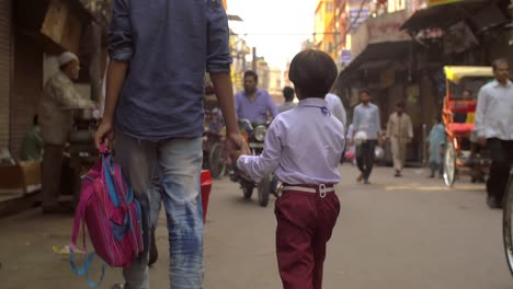 father and child holding hands on busy street