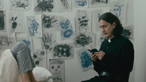 psychiatric patient listening to priest reading bible aloud in hospital ward