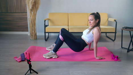 woman doing a home workout with resistance band and dumbbells