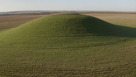 large grassy mound in an open landscape