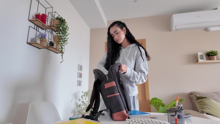 A woman packing a backpack at home