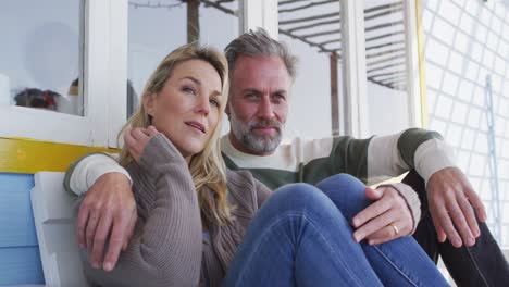 happy caucasian mature couple sitting on the terrace by the sea