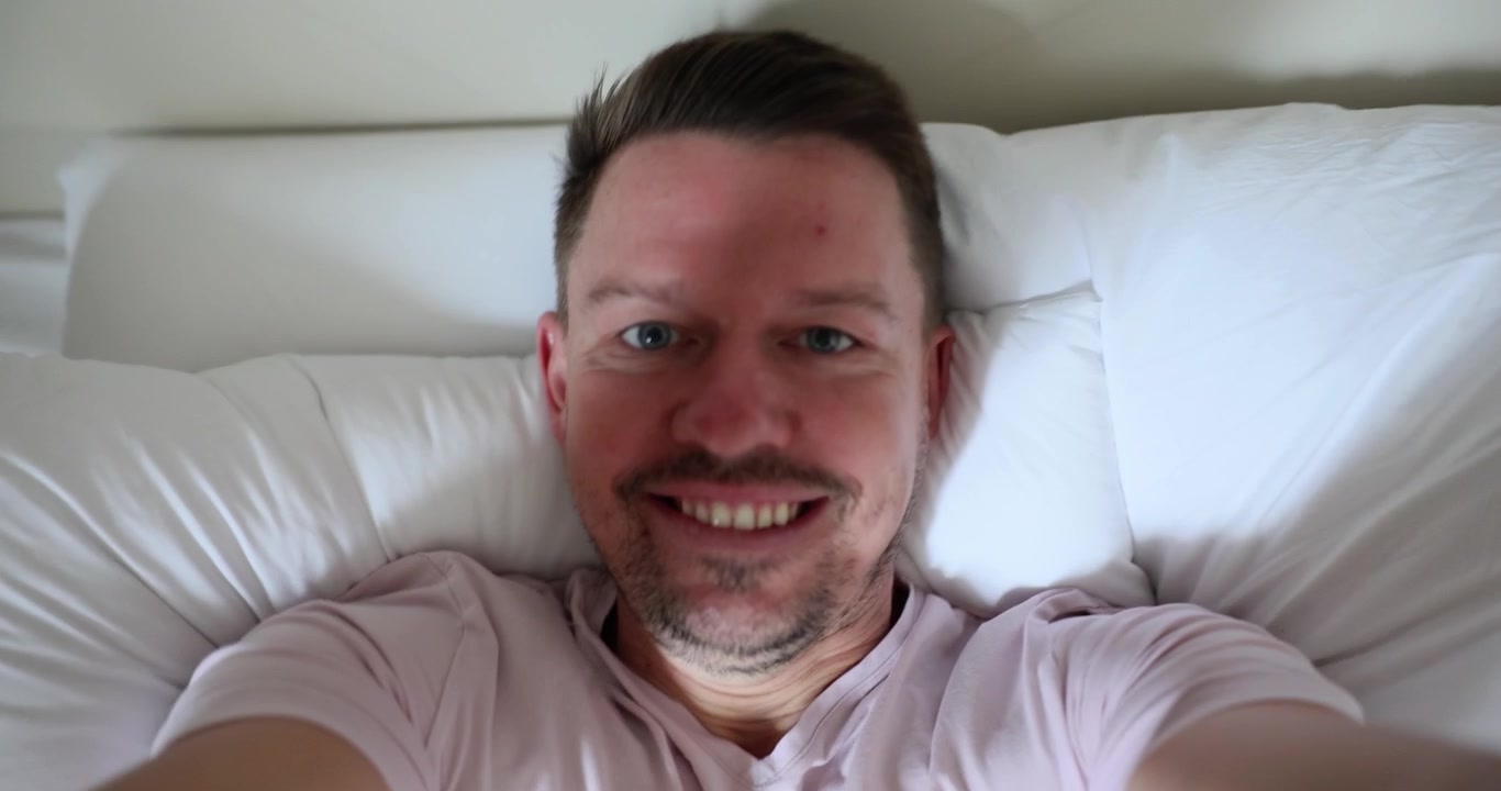 Catturare la gioia mattutina con selfie giocosi in un'accogliente camera da letto.