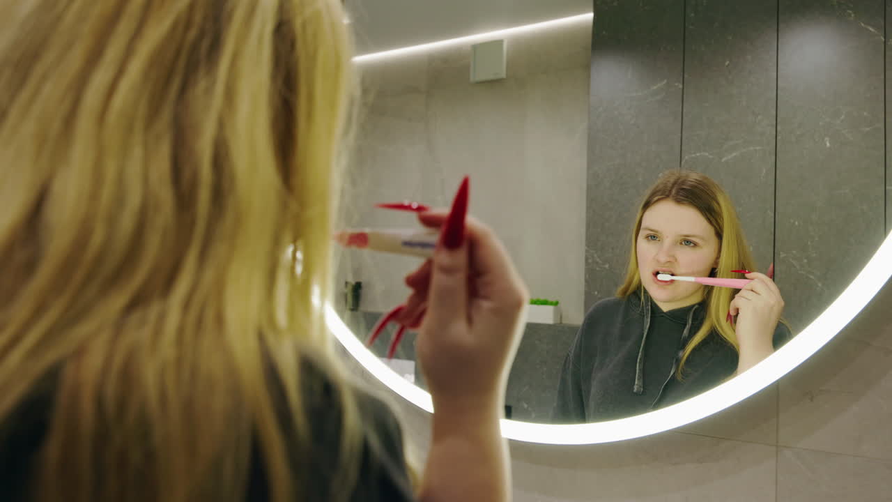 mujer cepillándose los dientes en el baño