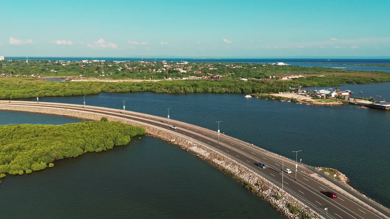 Cinematic 4K aerial drone footage of a coastal highway winding through mangrove forests and blue ocean waters in Cebu, Philippines. Perfect for tourism, environment, sustainability, and infrastructure