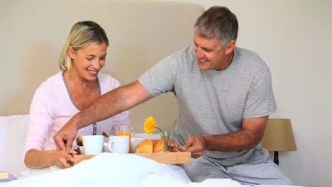 hombre trayendo a su esposa el desayuno en la cama