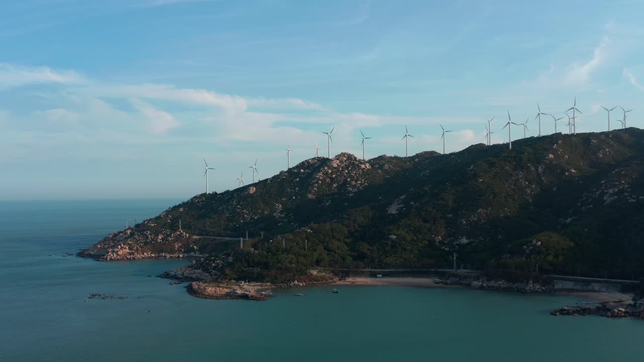 화창한 날 해변 산 능선 위에 풍력 발전기 농장