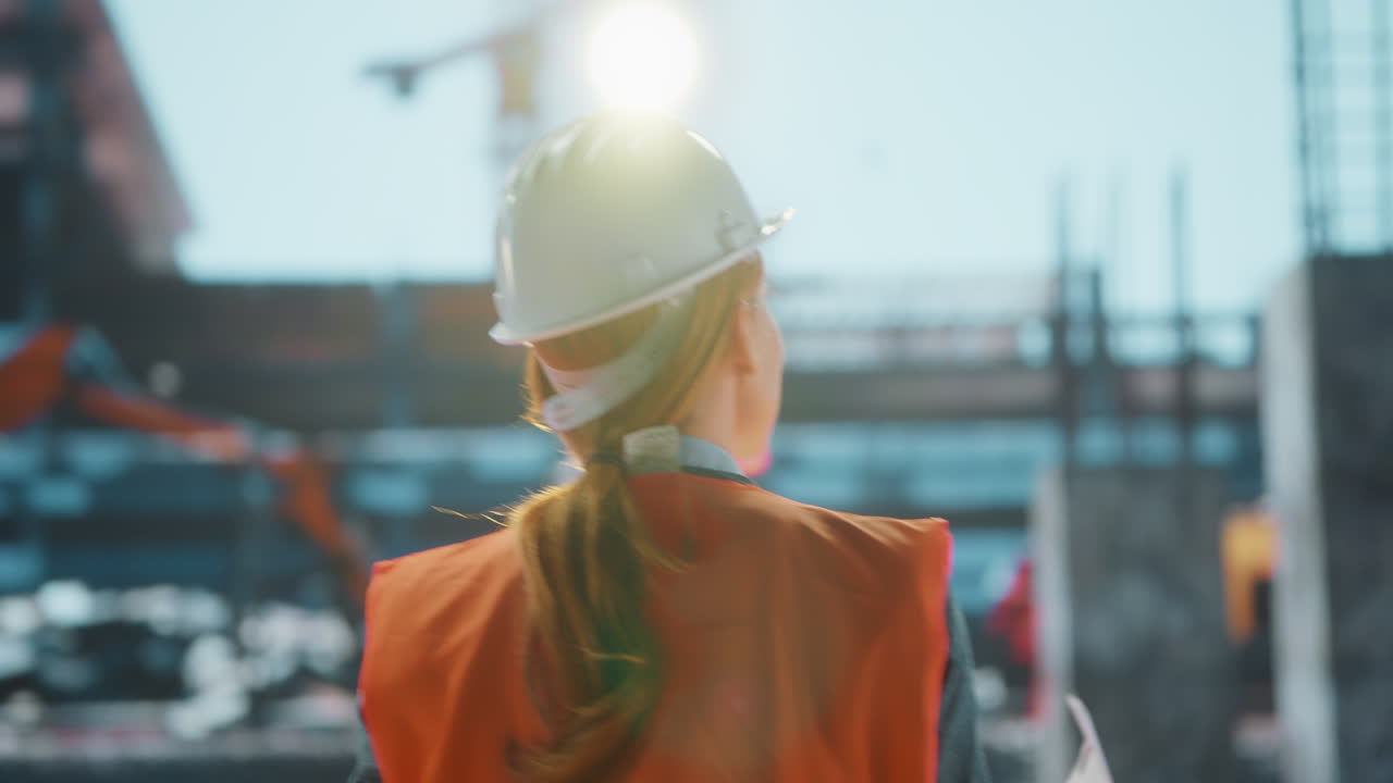 Female Engineer Inspecting a Construction Site with Blueprints