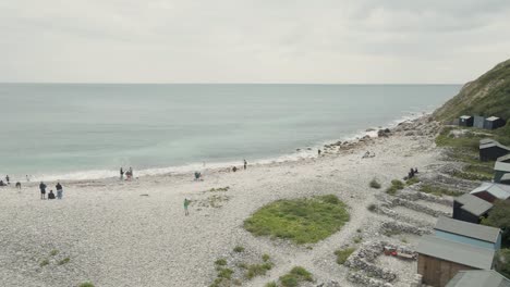 Aerial-shot-of-a-drone-flying-low-over-the-beach-of-Church-Ope,-to-then-continue-following-the-coast-line-of-the-island-of-Portland,-in-Dorset-UK