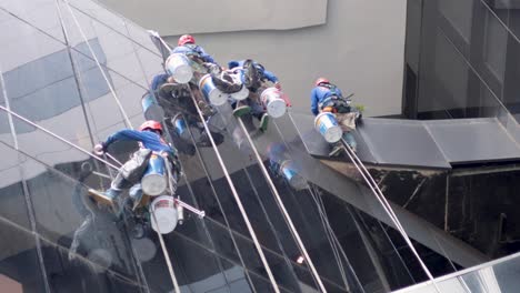 workers repairing windows on high-rise building