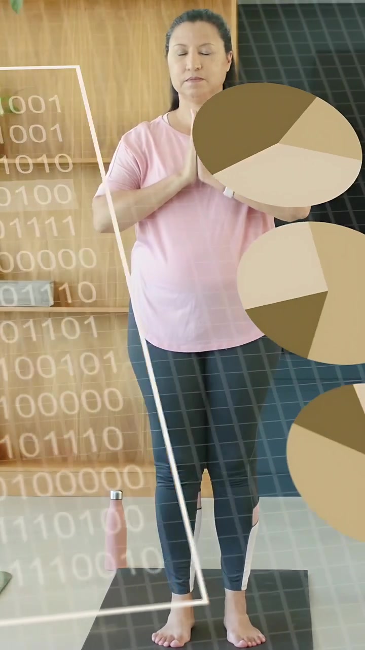 Vertikales Video: Frau steht betend auf einer Matte, ein binäres Raster erscheint und Diagramme überlagern Wellness-Daten.