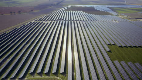 Reflejo-Del-Sol-En-Unidades-De-Campo-De-Granja-Solar-Sostenible-Durante-Un-Día-Soleado-En-El-área-Rural---Toma-De-órbita-Aérea