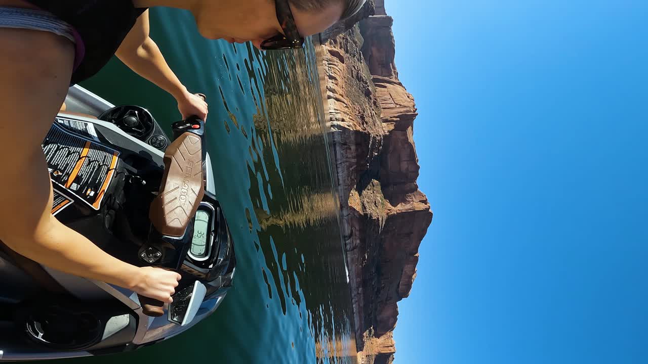mujer rubia de crucero en un scooter de agua en el lago powell en un día soleado