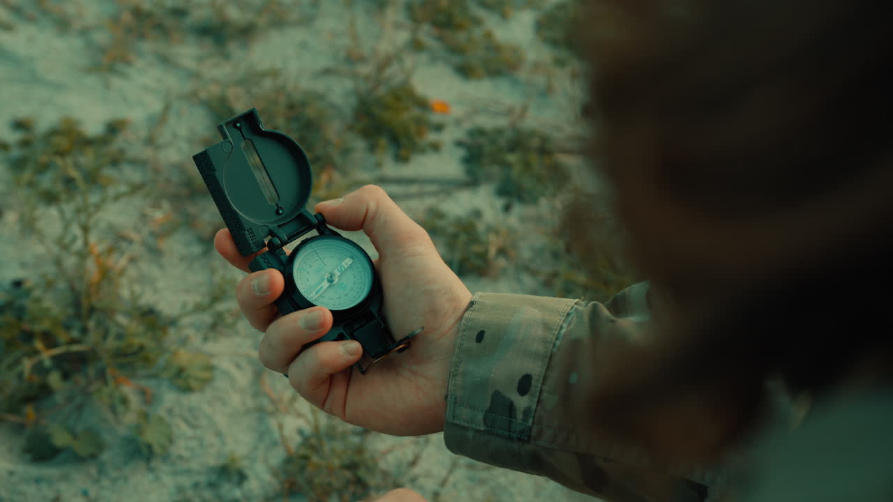 Soldier hand man checks compass in isolated desert