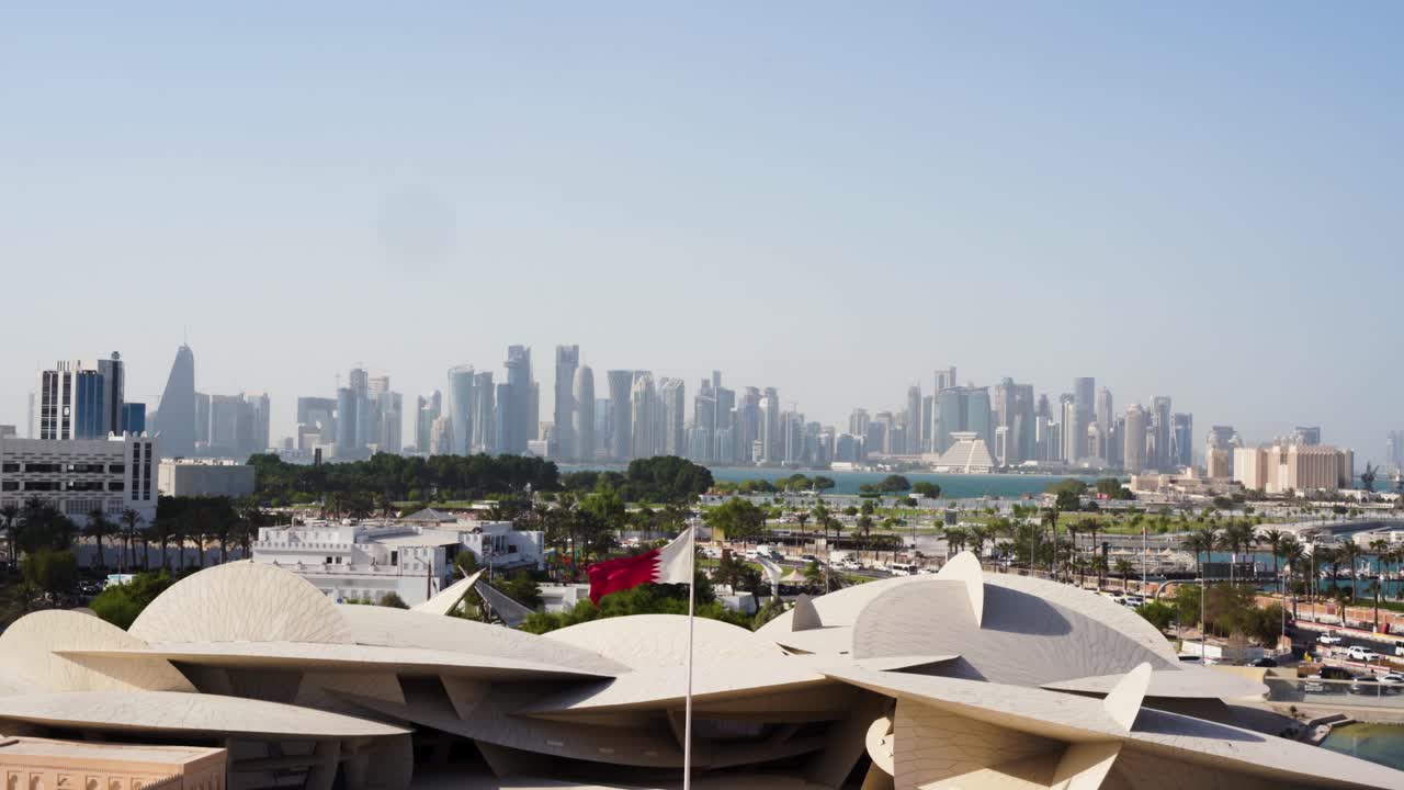 Doha, Qatars bysilhuett og nasjonalflagg i den varme vinden på dagtid