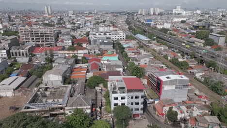 el tren de cercanías y el tráfico salen del norte de jakarta mientras el dron los persigue por los tejados.