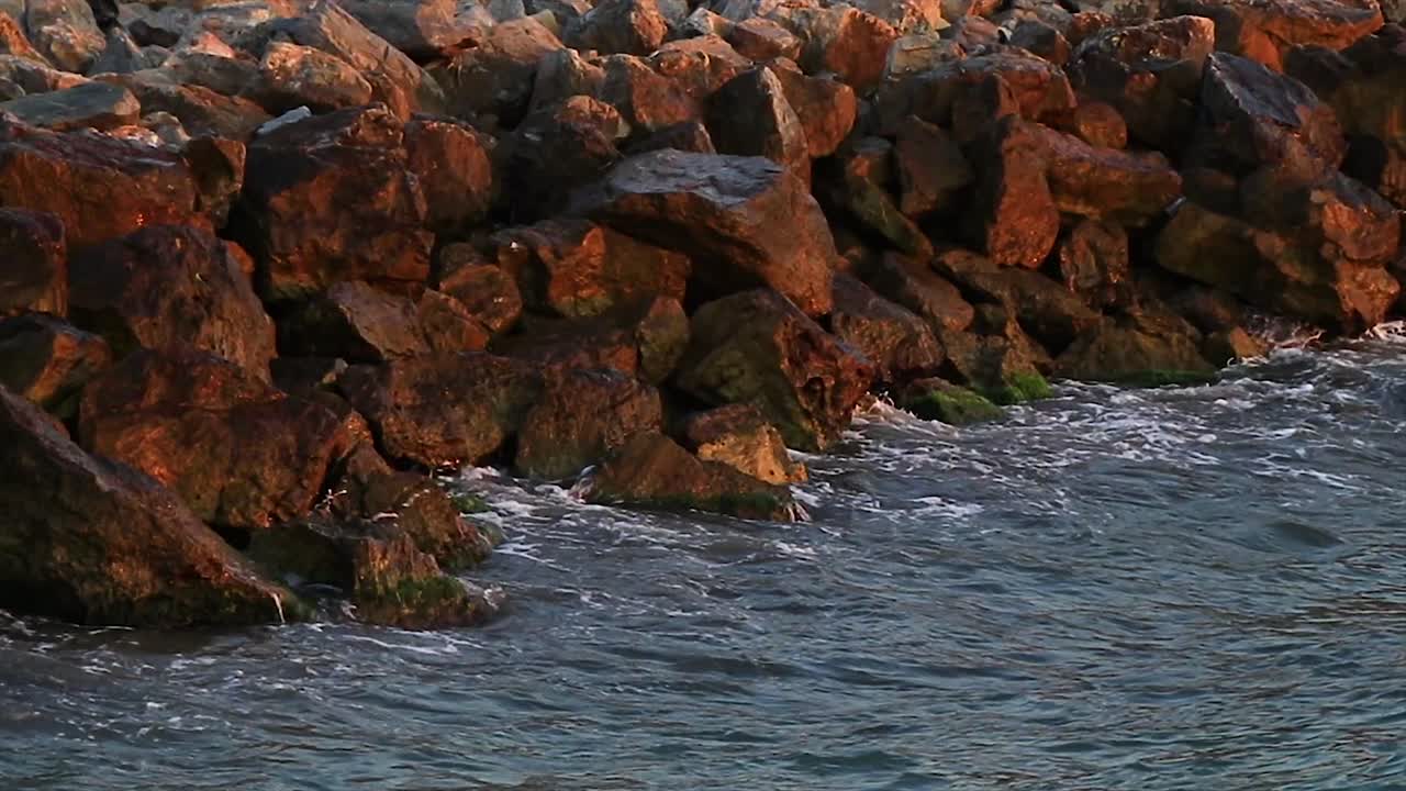 Scogli sulla costa e piccole onde che vi si infrangono.