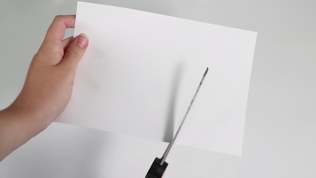 Mani che tagliano la carta con le forbici nel tempo