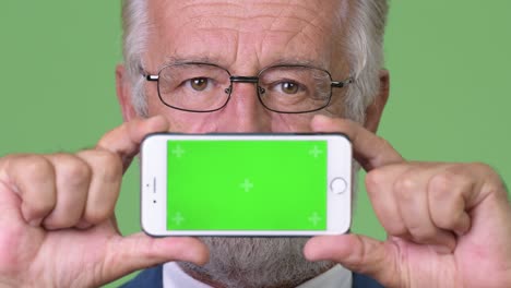 hombre de negocios barbudo y guapo contra un fondo verde.