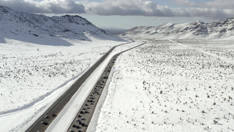 Luftaufnahme-über-Dem-Verkehr,-Der-Sich-Entlang-Der-Schneebedeckten-Bergstraßenszene-Bewegt