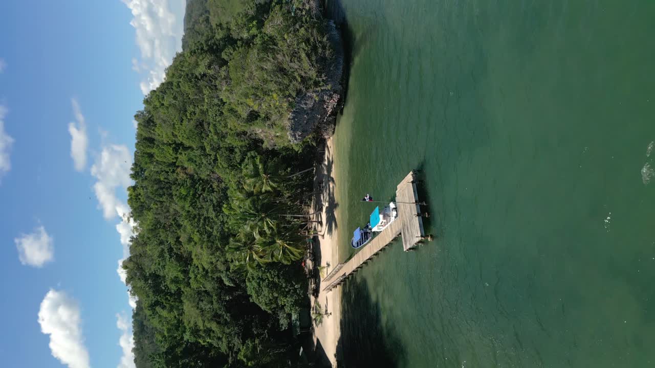 도미니카 공화국의 로스 하이티스 국립 공원 산 로렌조 만 지역의 개인 해변에 정박한 보트와 함께 핫 피어