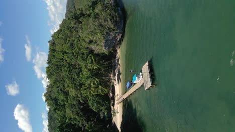 hot pier with boats anchored by a private beach in the san lorenzo bay area of los haitises national park, dominican republic