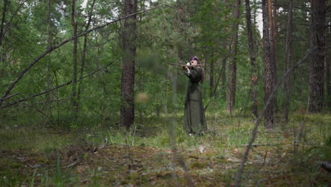 la chica arquera dispara una ballesta con una flecha suave en el bosque de abeto