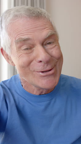 vertical video of portrait of happy senior caucasian man having video call in slow motion