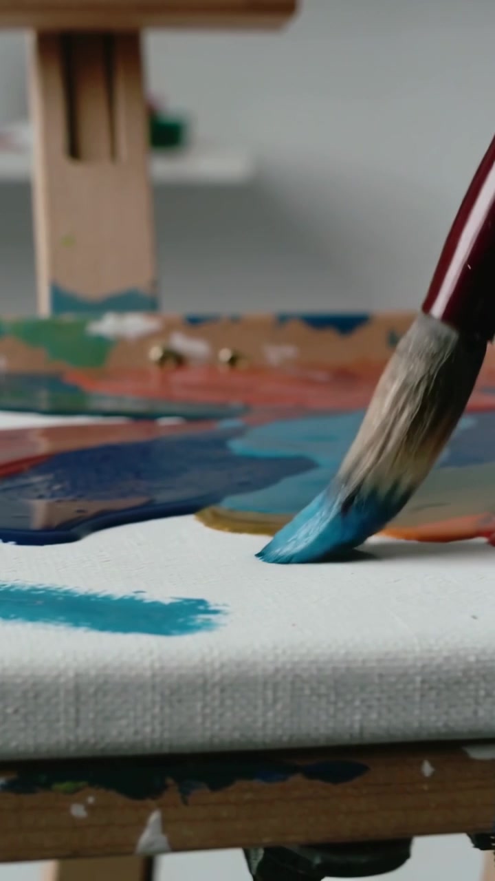 Video verticale: Toccando la pittura, pennello che traccia una pennellata blu su tela in studio per sfumare, spazio per il testo