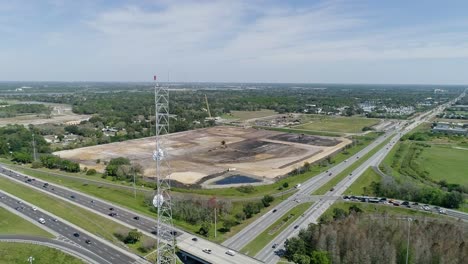 orbit shot of a radio tower next to highway in florida on a sunny day with an eagle