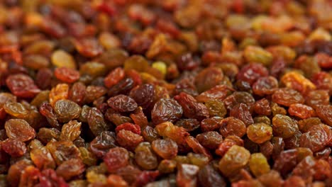 looped spinning full frame background of yellow and brown raisins pile