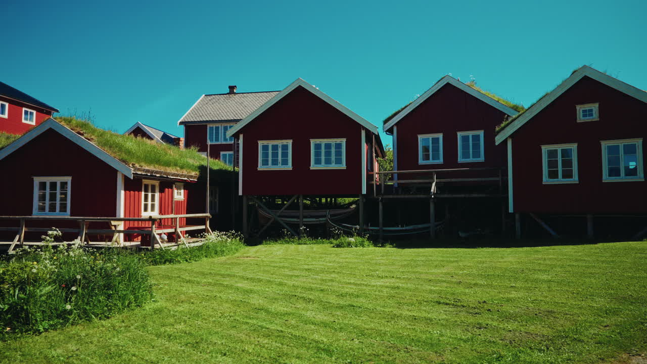Panoramic view of the red wooden fishermen cabins in the Lofoten islands, Norway. View of the picturesque landscape in the background