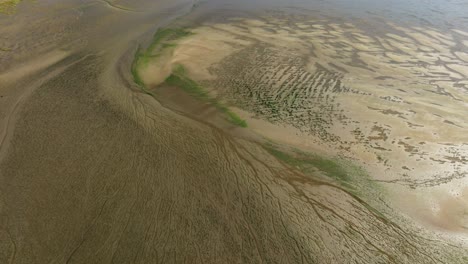 Langsame-Luftaufnahme-Des-Wattenmeeres-Des-Slikken-van-Voorne-Deltas-Im-Rheindelta-Mit-Bächen-Und-Mustern,-Die-Durch-Die-Gezeiten-In-Den-Sand-Geätzt-Wurden