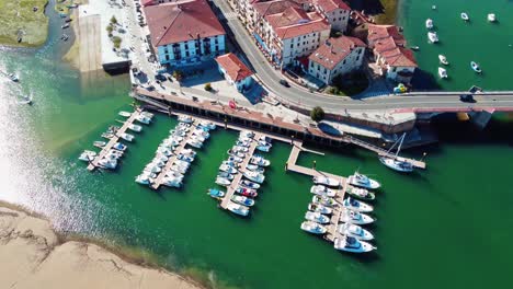 pequeño puerto con embarcaciones deportivas y gente paseando por el paseo marítimo de san vicente de la barquera, cantabria, españa en un hermoso día soleado