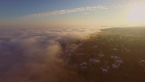 Fog-coming-in-from-the-Atlantic-ocean-during-sunset-at-Luz,-Algarve,-Portugal