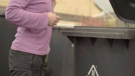 woman opening the garbage bin lid