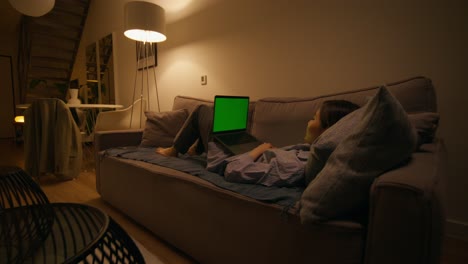 mujer relajándose en el sofá con una computadora portátil