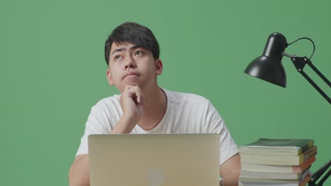 노트북 과 책 을 가지고 공부 하는 젊은 남자
