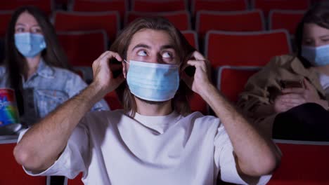 people in a movie theater wearing masks