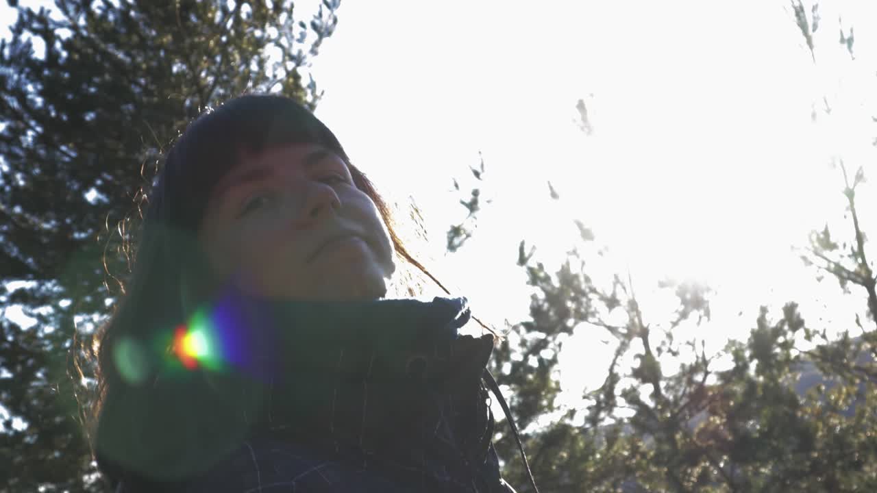 화창한 겨울날 자연 속을 걷는 갈색 머리를 가진 소녀의 느린 움직임