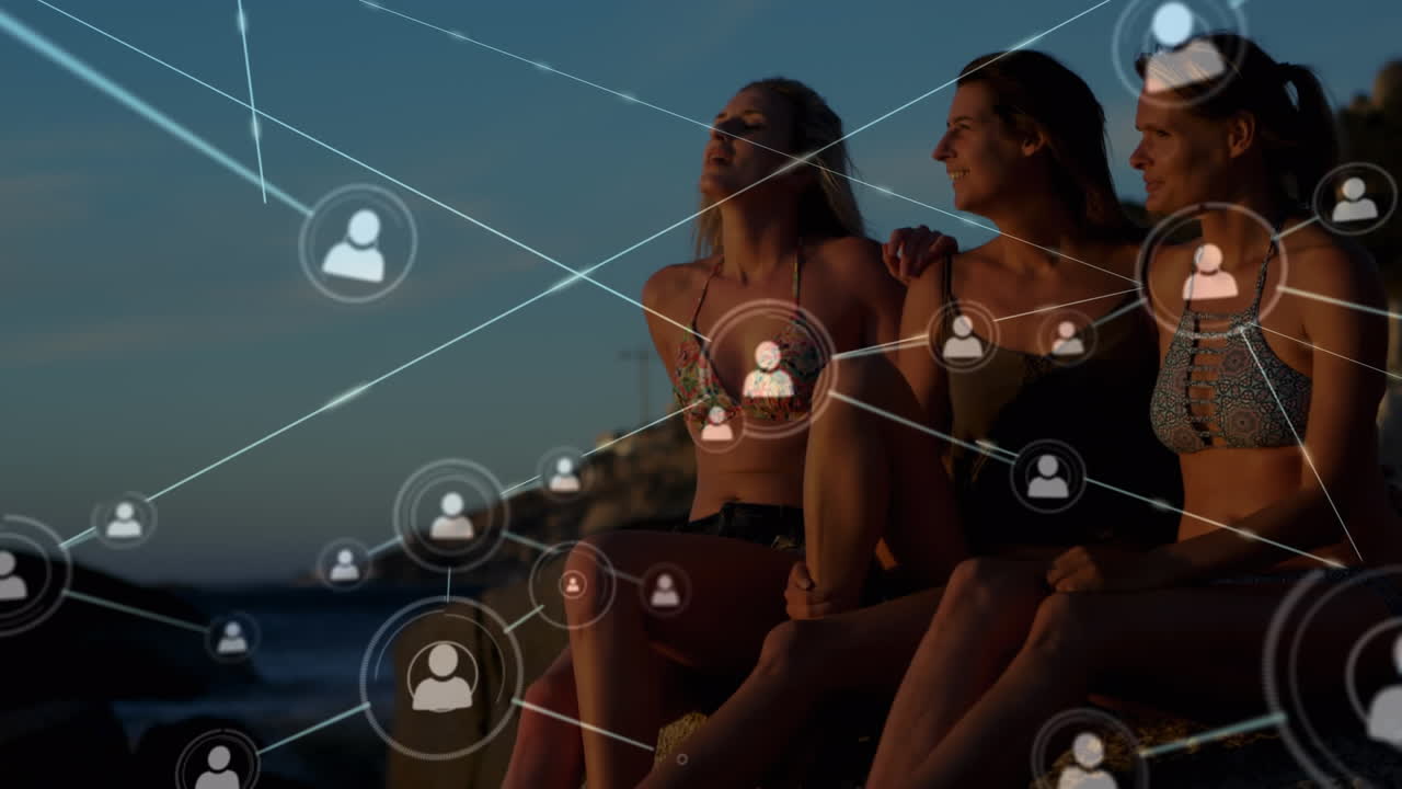 animación de una red de conexiones sobre amigas abrazándose en la playa