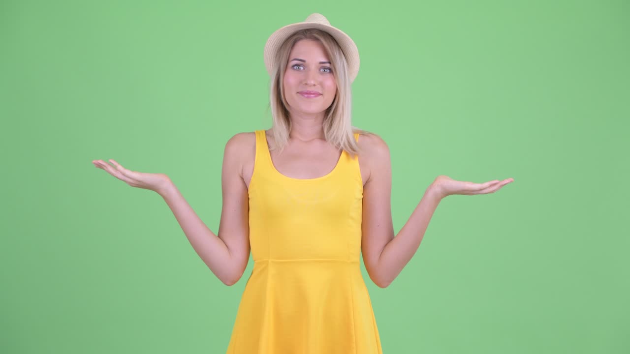 젊은 관광 여성이 녹색 배경에 미소 짓고 복사 공간을 들고 있는 스튜디오