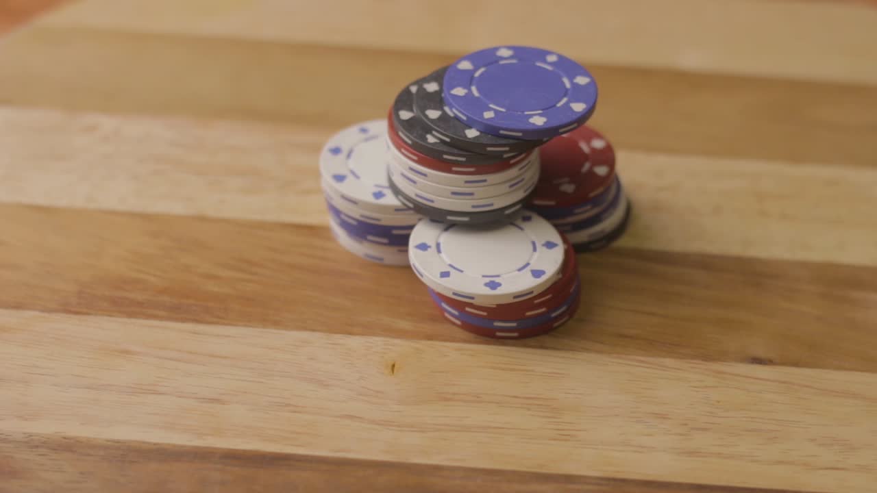 pan right close up of a man pushing four stacks of poker chips