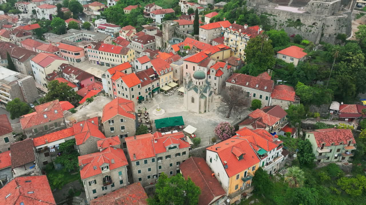 교회와 오렌지색 지붕이 있는 헤르체그 노비 구시가지 광장 위의 비행; 드론