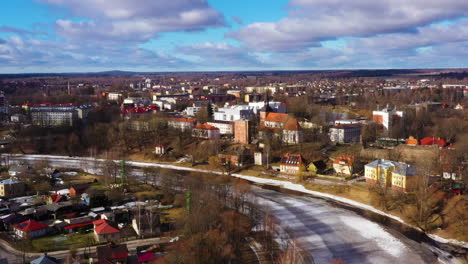 Imágenes-Aéreas-De-Valmiera-Letonia,-Volando-Sobre-El-Río-Gauja-Hacia-El-Centro-Comercial-&quot;Valleta&quot;