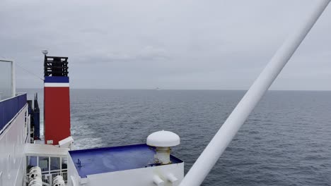 shot of a ship on an ocean in europe looking backwards towards the horizon with a chimney