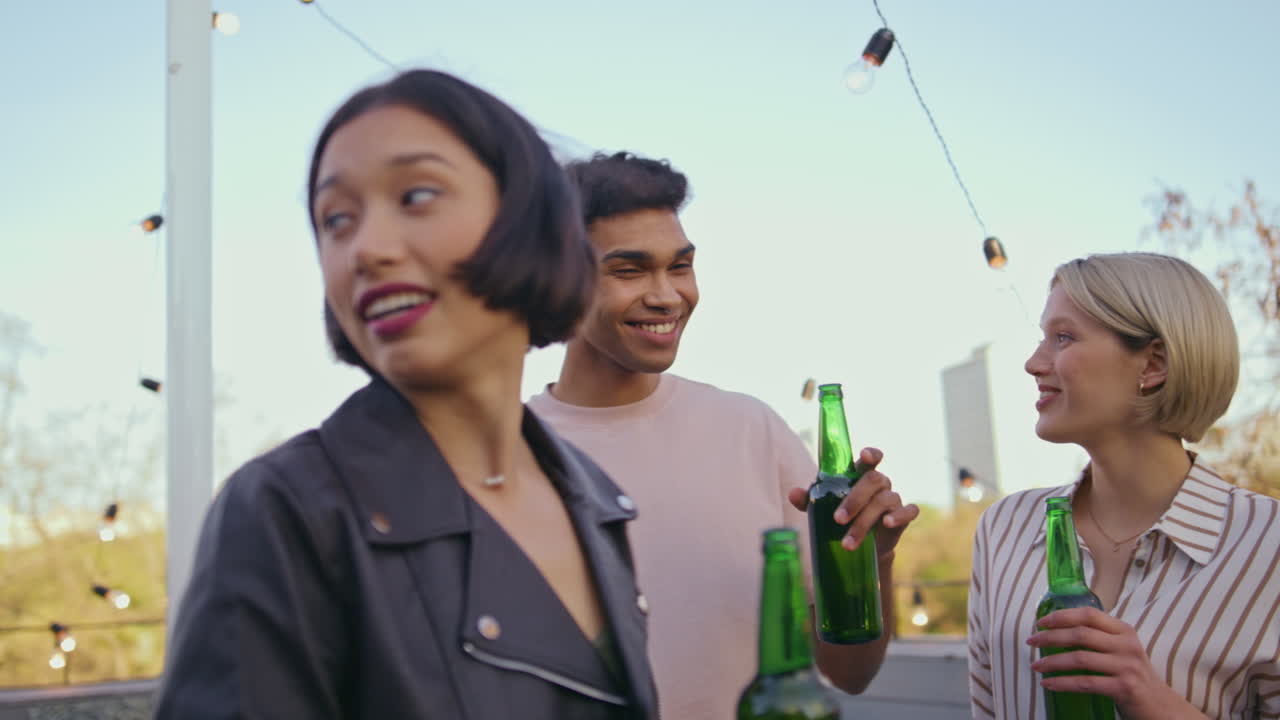 Young coworkers cheering alcohol party closeup. Diverse hipsters clinking beer