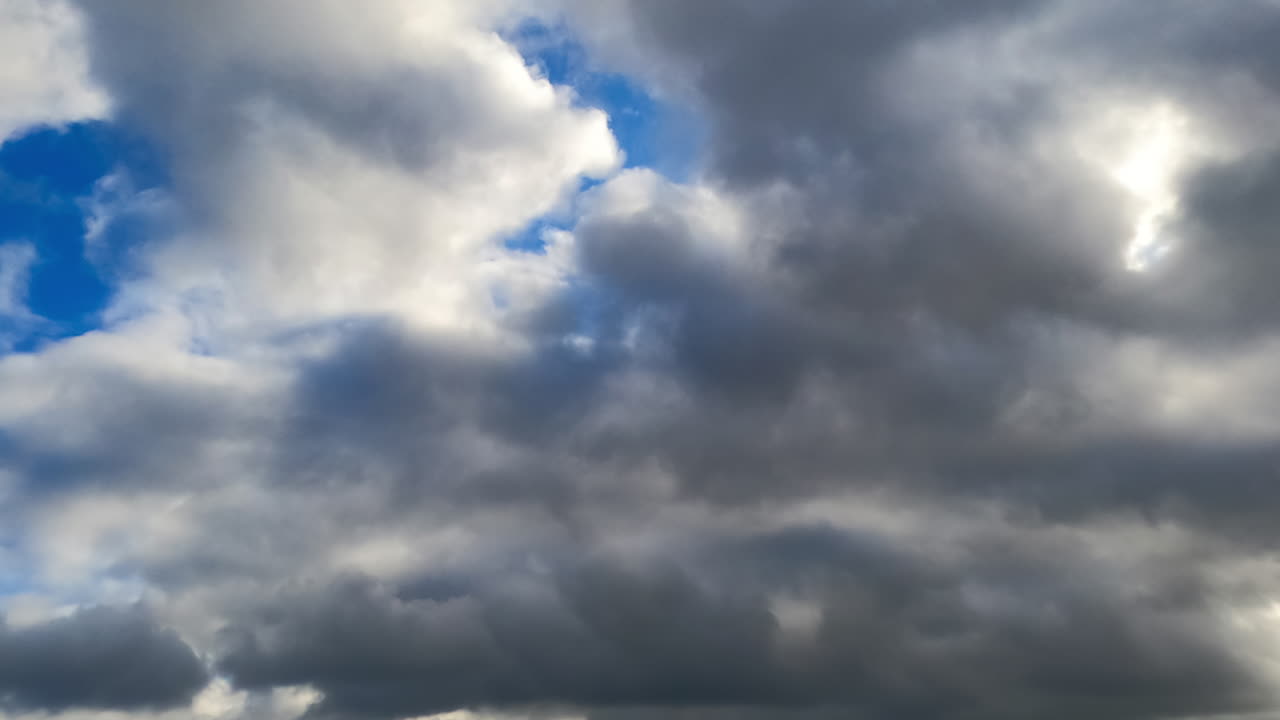Timelapse of fast-moving clouds. Timelapse captures clouds drifting and changing shape in a dynamic sky during the day, showcasing their swift movement